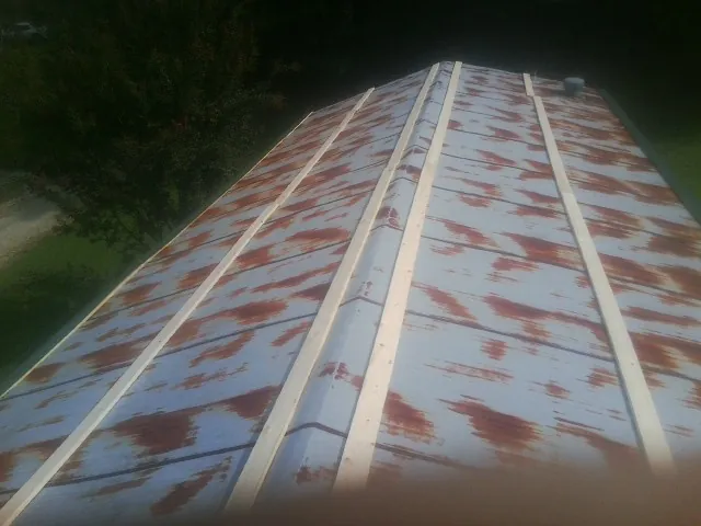Rusted metal roof panels with new wood purlins before replacement — Storm Damage Roof Repair in Syracuse by Roofing Brothers