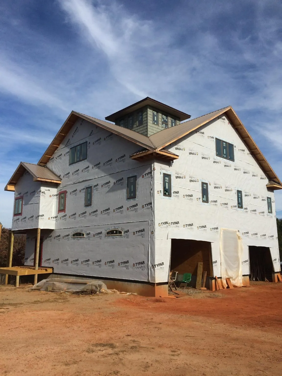 New two story house under construction with a cupola and gabled roofs in Syracuse